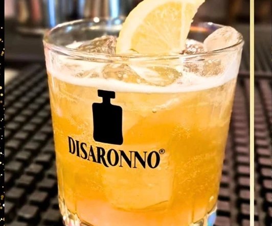 Long drink con fetta di limone servito al bancone del lounge bar a Ostia
