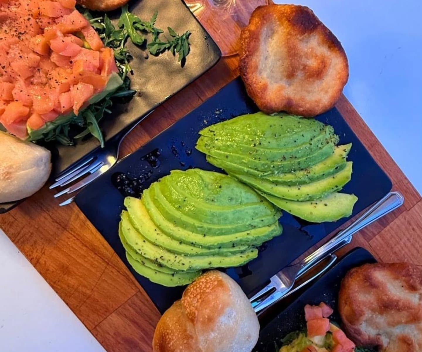 Tagliere con salmone, avocado e pizzette fritte per l’aperitivo a Ostia